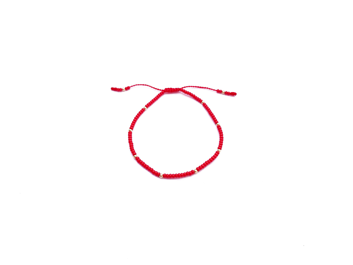 Pulsera roja tejida con puntos de oro