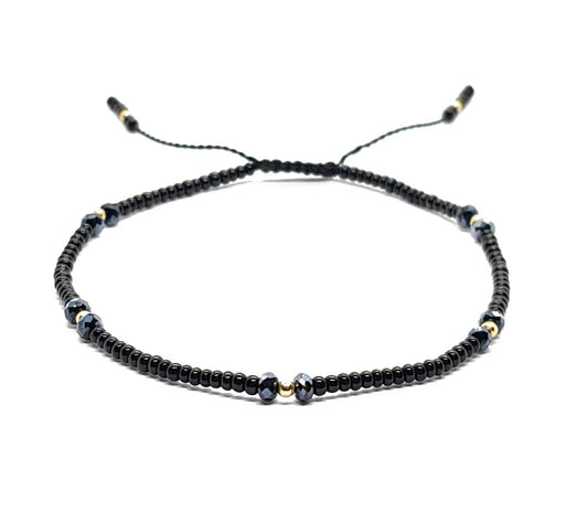 Pulsera negra con cristales y puntos de oro